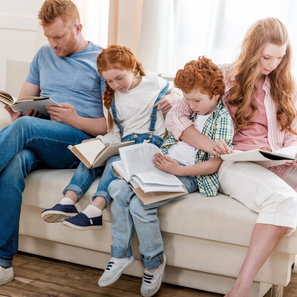 family reading together on the couch, each with a different book in their hand