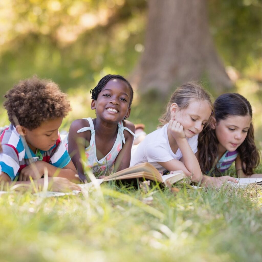 group of children reading books outside