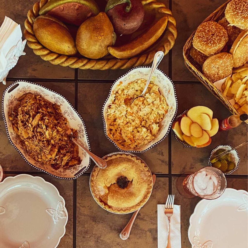 picture looking down on a table with a meal of bbq and side items on it