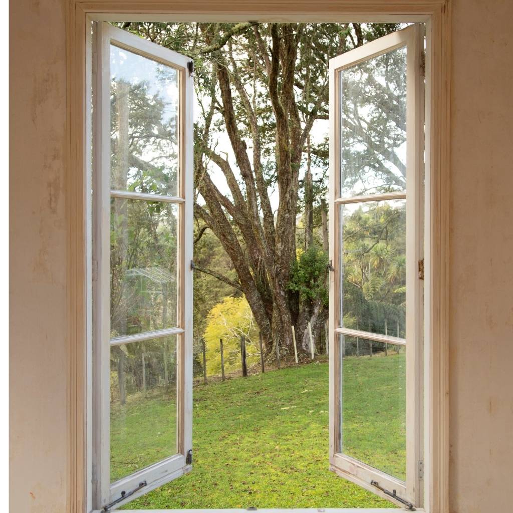 open glass window looking out to grass and trees