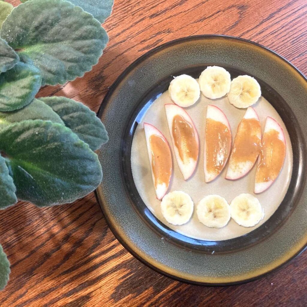 Plate with apple slices with peanut butter and slices of bananas