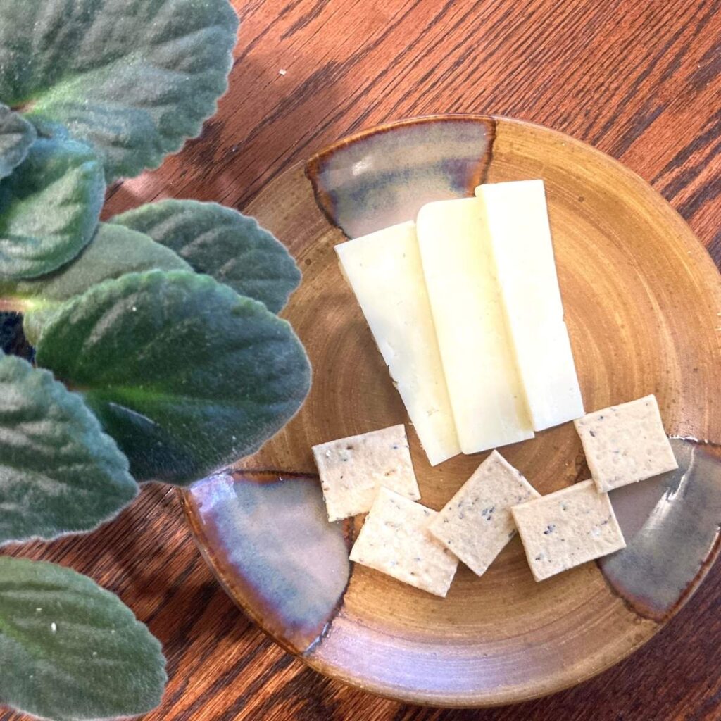Plate with slices of cheese and organic sourdough crackers