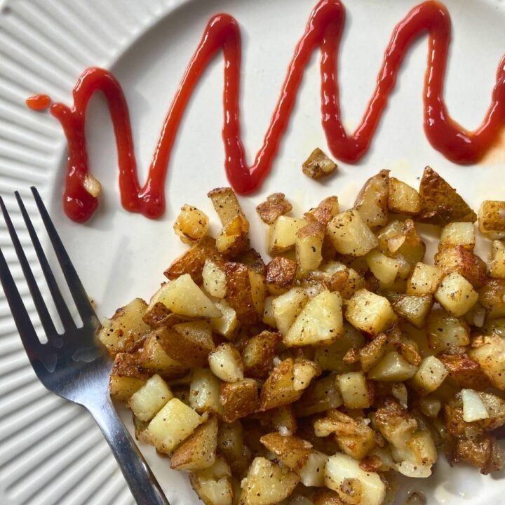 southern fried potatoes on a plate with a fork and ketchup