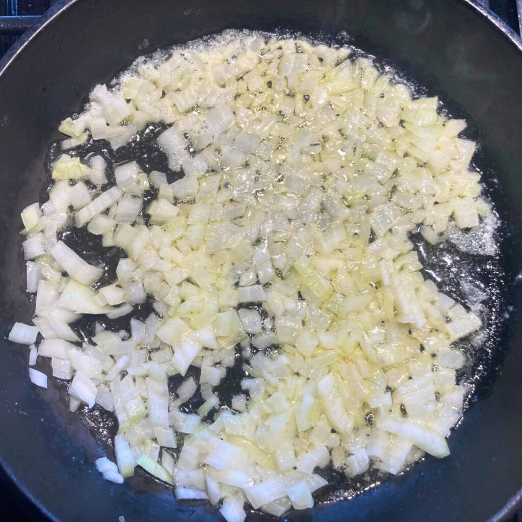 onions frying in butter in a cast iron skillet