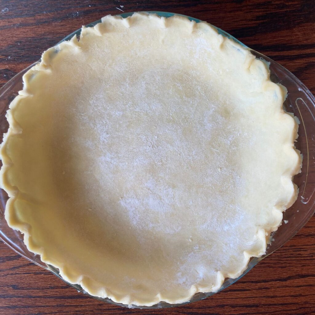 pie dough in a pie plate with crimped edges
